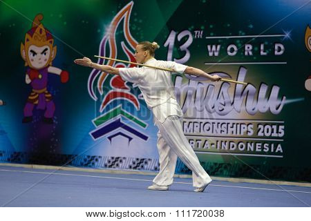 JAKARTA, INDONESIA - NOVEMBER 17, 2015: Daria Tarasova of Russia performs the movements in the women's Gunshu event at the 13th World Wushu Championship 2015 in Istora Senayan Stadium.