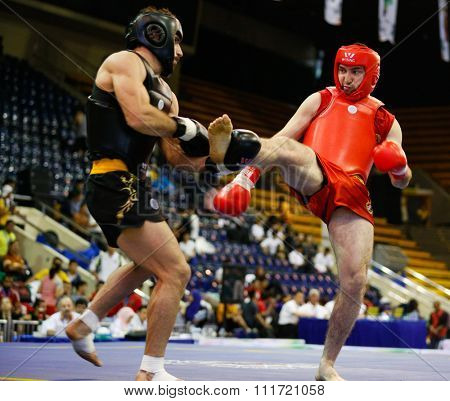 JAKARTA, INDONESIA - NOVEMBER 17, 2015: Arsian Bektemirov of Russia (red) fights Amir Fazli of Iran (black) in the men's 85kg Sanda semi-final event at the 13th World Wushu Championship 2015.