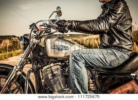 RUSSIA-JULY 7, 2013: Biker on bike Harley Sportster. Harley-Davidson sustains a large brand community which keeps active through clubs, events, and a museum. Filter applied in post-production.