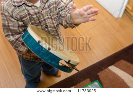 Small Child Playing On Drum
