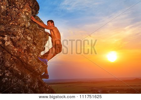 Young man climbing the mountain ridge