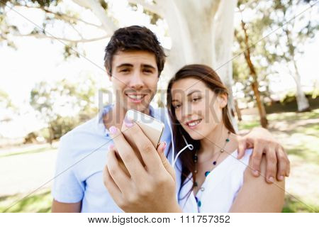 Young couple in the park making their selfi with mobile phone