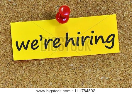 We're Hiring Word On Yellow Notepaper With Cork Background