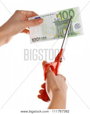 Hands with scissors cutting Euro banknote, isolated on white