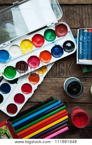 Art of Painting. Paint buckets on wood background. Different paint colors painting on wooden backgro