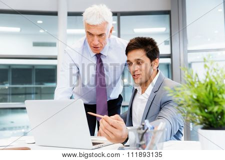 Two businessmen in fornt of computer in office