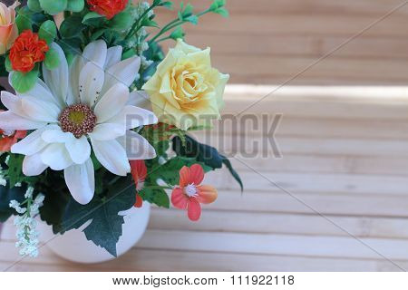 Beautiful Flowers In A Vase On A Wooden Brown Background