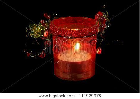 candle in red decorative candlestick on a black background