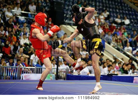 JAKARTA, INDONESIA - NOVEMBER 18, 2015: Hong Xing Kong of China (red) fights Ali Magomedov of Russia (black) in the men's 60kg Sanda final event at the 13th World Wushu Championship 2015.