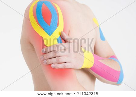 Kinesio tape kinesiology taping on man hand gray background