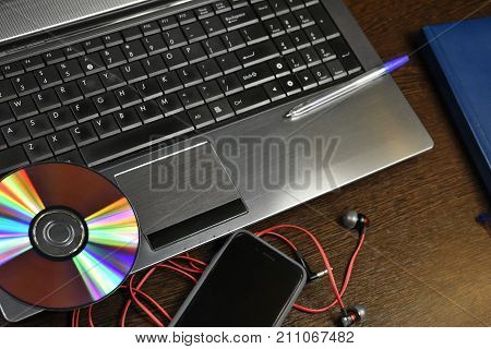 laptop headphones phone pen notebook on the desktop