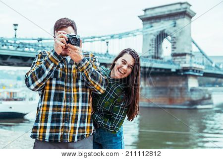 lovely cople taking picture old bridge on background