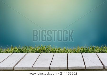Blue background and grass on a white wood floor.