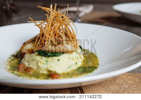mashed potato with meat on a white plate in a restaurant