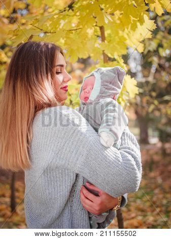 The girl is holding her son in the park