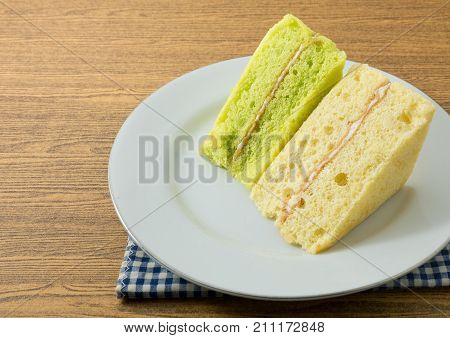 Snack and Dessert Pandan and Vanilla Chiffon Cake Made With Butter Eggs Sugar Flour Baking Powder and Flavorings on A White Dish with Copy Space for Text Decarated.