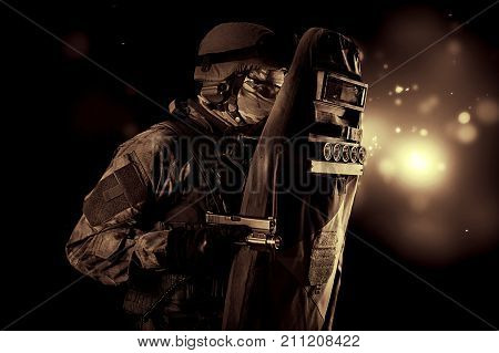 Armed With A Pistol, A Military Man In A Bulletproof Vest Covers Himself With A Shield.