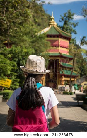 Girl with backpack entering to Quan Yin Shrine at Wat Tham Seua (Tham Seua Temple) Krabi Thailand.