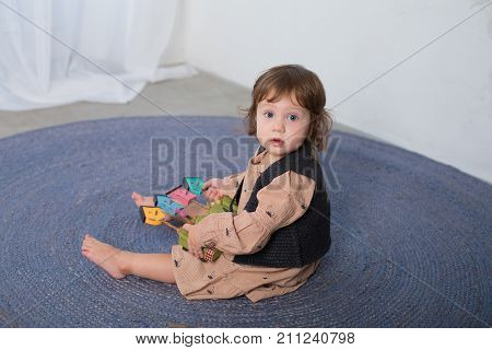 Little happy girl playing with toy on floor. Kindergarten.