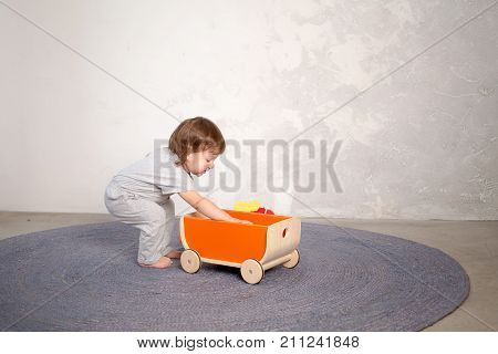 Little happy girl playing with toy on floor. Kindergarten.
