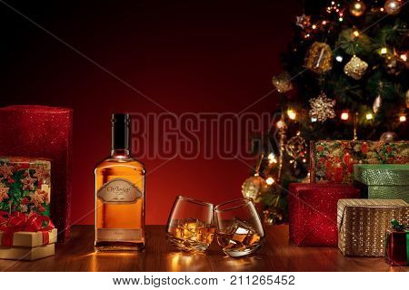 view  of bottle and two glasses with whiskey on color back. self made label.