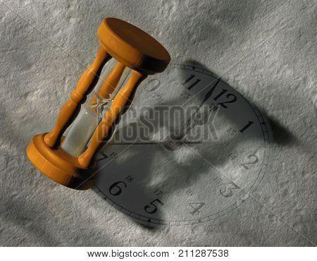 SAND TIMER CASTING SHADOW ON CLOCK FACE