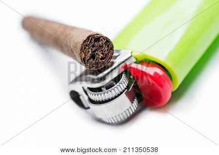 Macro Of A Cigarillo On Top Of A Green Lighter Isolated On White Background