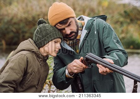 Father Showing Son How To Load Gun