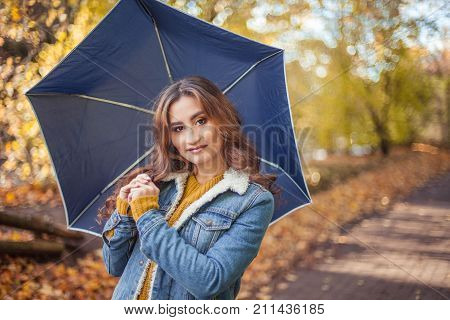 A Young Beautiful Woman Is Walking Along The Autumn Park With An Umberella In Her Hands. Autumn Port