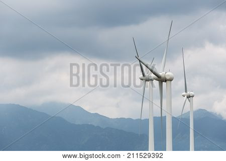 wind power generation turbines closeup on hillside in cloudy