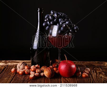 Autumn Collection. Glass of wine with boutle on  dark background