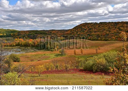 The hills are ablaze with the autumn colors of sumac and ma-ple trees.