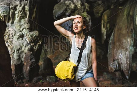 Young woman traveler at cave entrance on island hopping in Cheow Lan Lake - Wanderlust trip and travel concept with adventure girl tourist wanderer on excursion in Thailand - Warm contrast filter