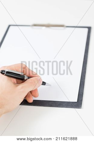 white paper on clipboard signed by hand