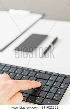 Workspace with keyboard, mobile phone, clipboard and pencil