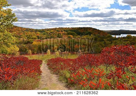 The hills are ablaze with the autumn colors of sumac and ma-ple trees