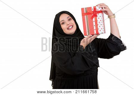 Happy young muslim woman with shopping bag and gift boxes isolated over white background.