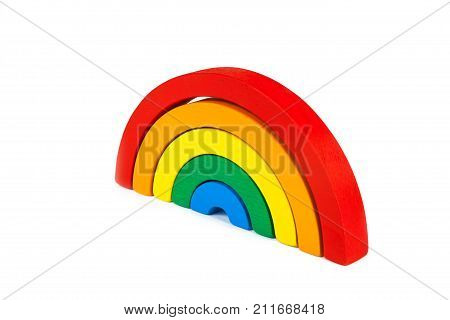 A wooden toy of seven different-colored arcs in the form of a rainbow on a white isolated background the arcs are folded like a rainbow