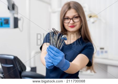 Woman Dentist With Blue Gloves Holding Tools - Dental Mirrors And Dental Sondes At The Dental Office