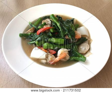 Tasty wide rice noodle in creamy gravy sauce with shrimp and squid traditional Chinese and Thai style food or called in Thai "Rad Na"