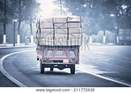 Small freight car with cardboard boxes. China.