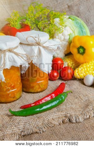 jars with winter supplies, banks with salad are on the table with vegetables