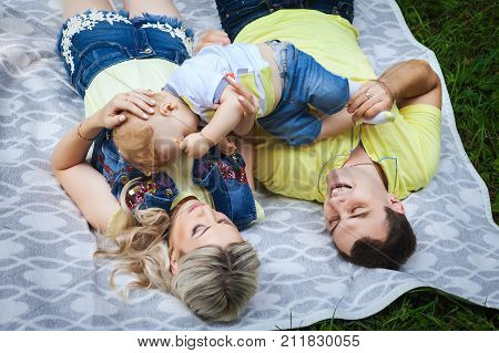 happy young family resting in city park, nice couple playing with his little baby, concept happy family