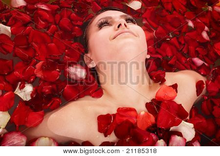 สาวสวยในอ่างจากุซซี่กับกุหลาบกลีบดอกไม้ การดูแลร่างกาย