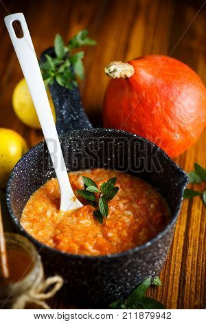 sweet pumpkin porridge with honey on a wooden table