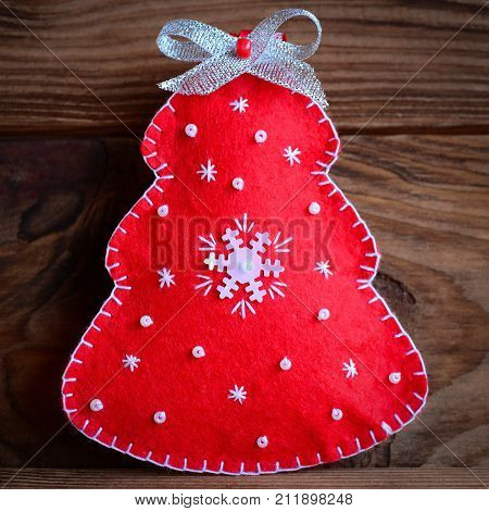 Christmas tree decoration. Red Christmas tree isolated on a brown wooden background. Closeup