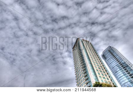 Two high rise buildings and sky with clouds