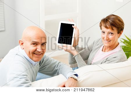 Mature Couple Displaying A Blank Tablet-pc