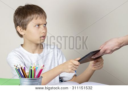 Video Games Addiction. Mother Taking Tablet Away From The Kid Hands
