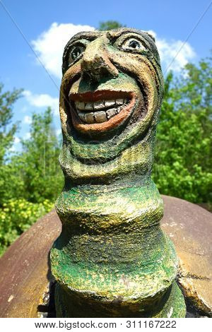 Mytishchi, Russia - September 2016: Magic worm in a dwarf mushroom house. Small fabulous skulpture in the city park.